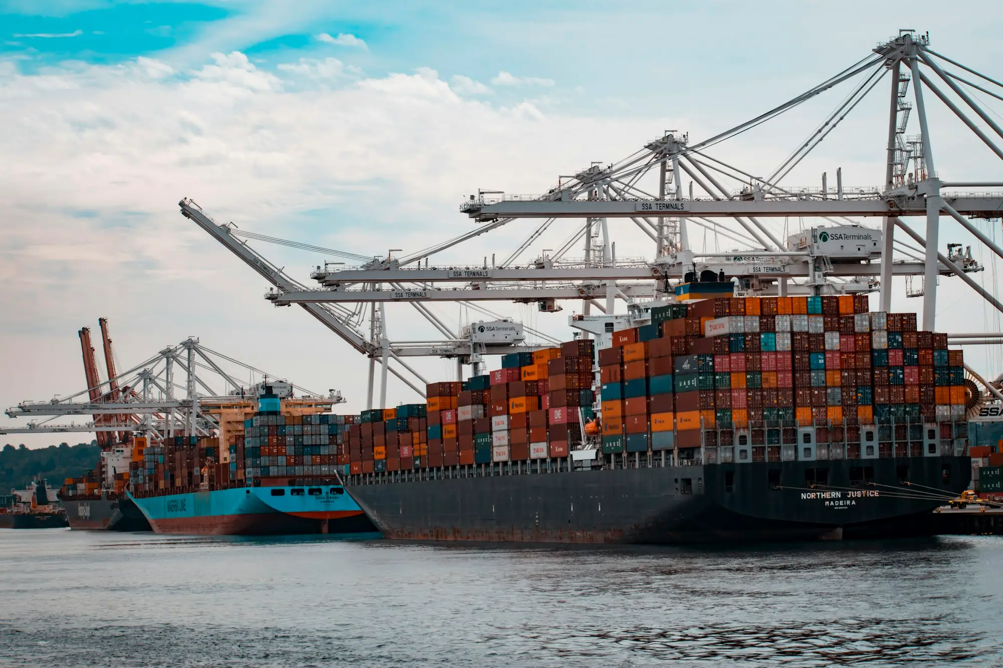 Shipping containers stacked at a port at dusk